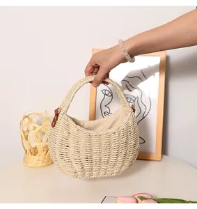 Close-up detail of a handheld bohemian cream woven straw handbag for summer beach vacations