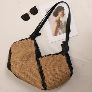 Large French-style woven straw tote bag with black trim and long shoulder straps.