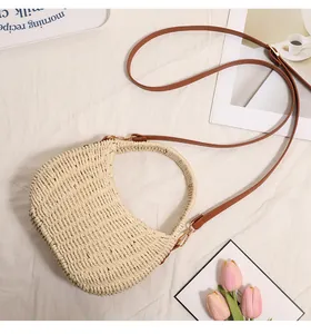 Detailed view of handwoven straw basket bag with brown strap for beach vacation