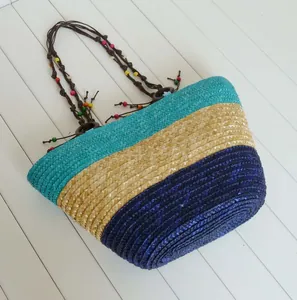 Handcrafted striped straw beach bag with colorful beaded straps and vacation style