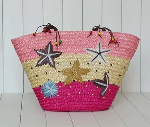 Handcrafted colorful straw beach bag with starfish patterns and floral details for seaside resort