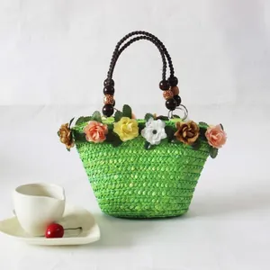 Handgemaakte groene geweven rieten tas met kleurrijke kunstmatige bloemen
