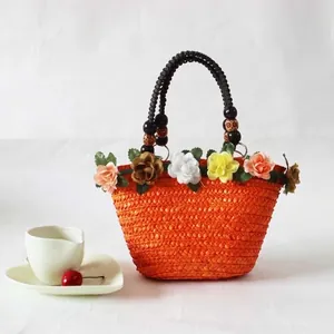 Oranje handgeweven strooien strandtas met kleurrijke bloemen en kralen handvatten