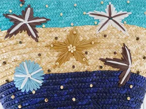 Macro detail of a colorful straw woven beach bag featuring starfish decorations and beads