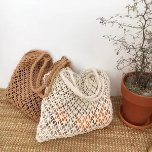 Vista dettagliata di borse da spiaggia boho in rete di cotone intrecciata beige e marrone
