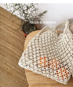 Dettaglio di una borsa in rete di cotone macramè con arance in ambiente naturale