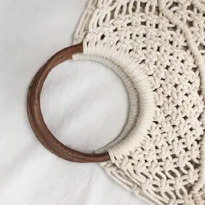 Detalle de cerca de un bolso de playa de macramé tejido a mano con asa redonda de madera