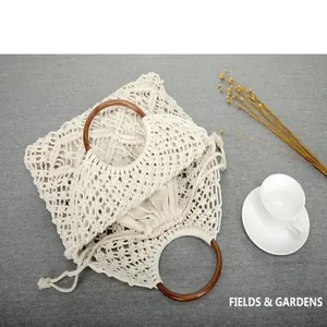 Primer plano del tejido de macramé y las asas circulares de madera de este bolso