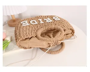 Detalle de bolso de paja con letras 'BRIDE' de perlas y forro con cordón ajustable.