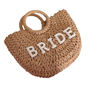Bolso de playa de paja tejida con letras de perlas 'BRIDE' y asas redondeadas