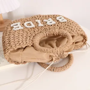 Bolso de mano de paja tejida con letras de perlas BRIDE para bodas en la playa