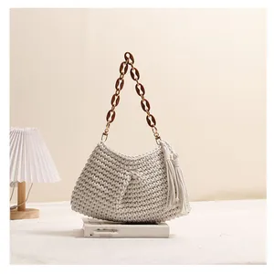 Detail van de handgemaakte crème katoenen geweven tas met kwastje en mooie ketting
