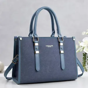Detailansicht einer blauen Handtasche mit Denim-Textur und feinen Gold-Details