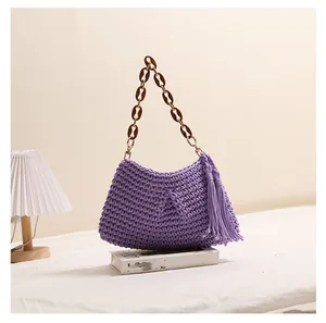 Detailopname van de handgeweven paarse textuur en de elegante kwast van deze strandtas