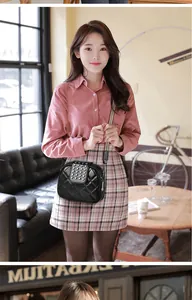 Asian model wearing a black studded quilted crossbody bag with a wide patterned strap