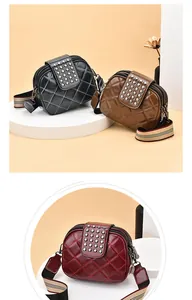 Detail of quilted crossbody bags with decorative rivets and wide striped shoulder straps