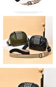 Close-up detail of quilted crossbody bag featuring metal rivets and a wide striped strap