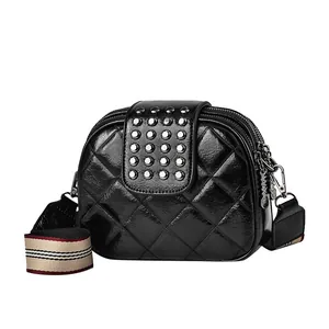 Chic black quilted crossbody bag with silver rivets and colorful wide woven strap