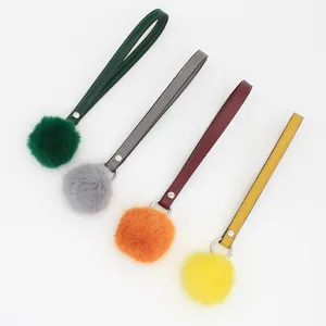 Close-up detail view of four colorful PU leather pom pom keychain straps for bags and phones