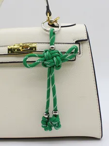 Dettaglio del ciondolo a nodo cinese verde intrecciato a mano per borsa decorativa