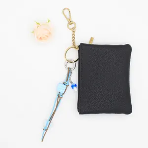 Détail d'un bijou de sac tressé à la main avec perle à carreaux bleue et champignon