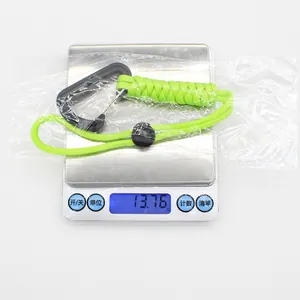 Neon green tactical paracord keychain on a scale showing its weight of 13.76g.