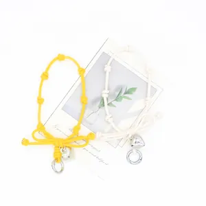 Detail of yellow and white bow-knot braided phone wrist straps with heart charms