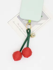 Detailed view of the red PU leather cherry charm with intricate layered petals and gold bell.