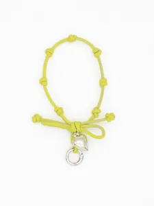 Detail of a lime green braided phone wrist strap with a shiny silver heart charm