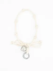 Detailed view of woven knot phone lanyard with cream bow and silver heart pendant