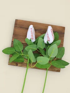 Vue détaillée de deux roses artificielles en cuir de baseball sur une planche en bois.