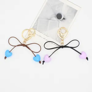 Exquisite macaron heart bow keychains with gold clasps on minimalist background