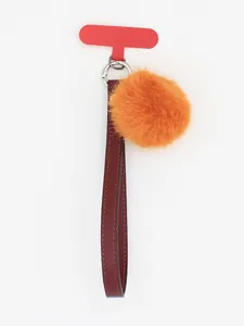 Detailed view of dark red PU leather strap with bright orange fluffy pom-pom keychain