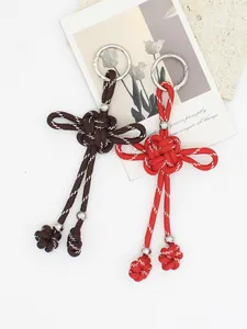 Portachiavi con nodo cinese intrecciato a mano in rosso e marrone con perline d'argento.