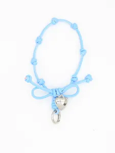 Close-up of a light blue woven bow phone wrist strap with a silver heart charm.