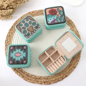 Detailed view of mint green square jewelry boxes with embossed floral patterns and inner mirror