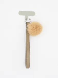 Detail view of the tan PU leather wrist strap with fluffy fur ball and phone tether tab.