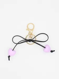 Detail shot of the black bow and lavender heart beads on the exquisite macaron keychain