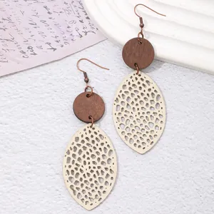 Close-up of bohemian hollow wood and cream faux leather teardrop earrings detail
