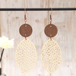 Macro detail of bohemian hollow mesh teardrop wood and leather earrings