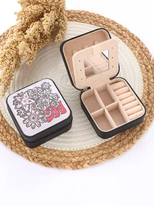 Interior and exterior detail of a portable jewelry box with floral pattern and letter M