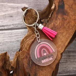 Detail view of an acrylic keychain with pink tassel and 'I love you MOM' rainbow print.