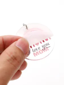 Close-up of acrylic keychain with Love you MOM text showing protective film removal