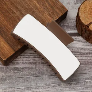 Detail shot of brown PU heat transfer hair claw clip for DIY printing on wood background