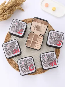 Portable floral jewelry boxes with red letter initials showing internal compartments