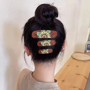 Back view of woman with hair bun decorated with vintage sunflower pattern clips.