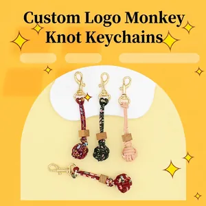 Detail view of handmade braided cord keychains with wooden beads and gold clasps.