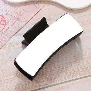 Close-up of black hair claw clip with white blank surface for DIY heat transfer printing