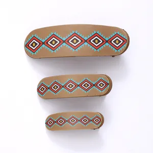 Set of three retro ethnic diamond pattern hair clips in graduated sizes on white background
