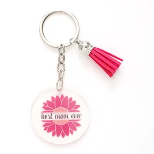 Close-up of the acrylic sunflower keychain featuring a pink tassel and mom-themed text.